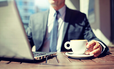 Image showing senior businessman with laptop and coffee outdoors