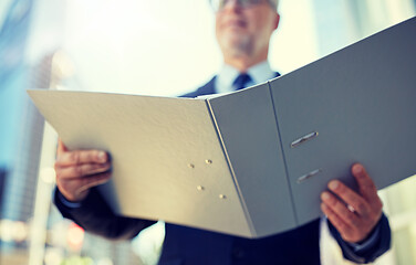 Image showing senior businessman with ring binder folder in city