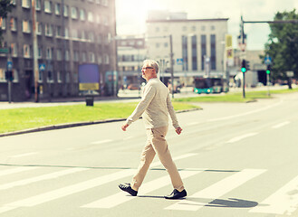 Image showing senior man walking along city crosswalk