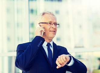 Image showing senior businessman calling on smartphone in city