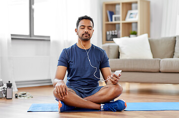 Image showing indian man with smartphone on exercise mat at home