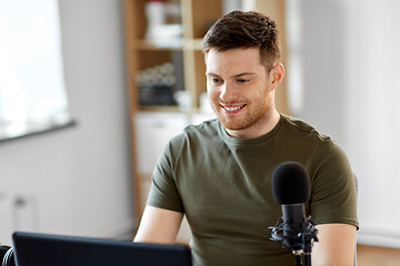 Image showing man with laptop and microphone at home office