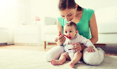 Image showing mother with spoon feeding little baby at home