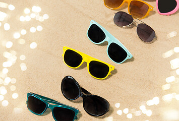 Image showing different sunglasses on beach sand