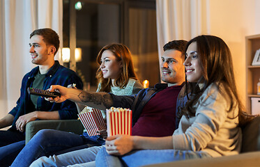 Image showing friends with popcorn watching tv at home