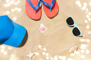 Image showing cap, flip flops, shades and on shells beach sand