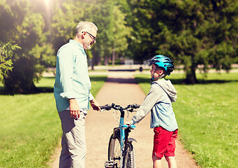 Image showing grandfather and boy with bicycle at summer park