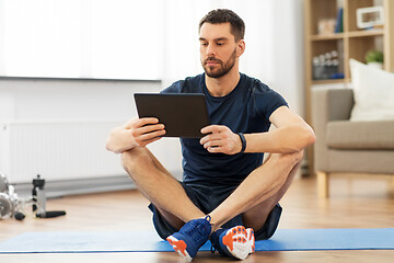 Image showing man with tablet computer on exercise mat at home