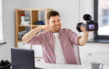 Image showing male blogger with camera videoblogging at home