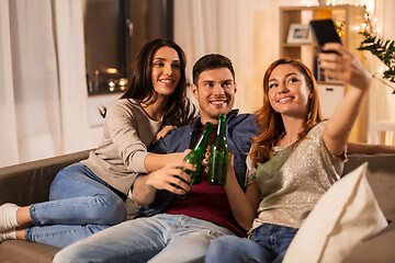 Image showing friends clinking drinks and taking selfie at home