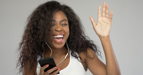 Image showing Happy ethnic woman listening to music and dancing