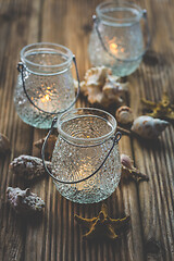 Image showing Three vintage lantern with sea shells on wooden table