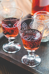 Image showing Two vintage glasses of red wine with bottle and lantern