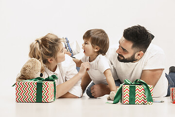 Image showing happy family with kid together and smiling at camera isolated on white