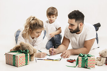 Image showing happy family with kid together and smiling at camera isolated on white