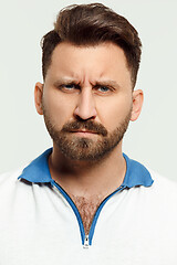 Image showing The serious man standing and looking at camera against white background.