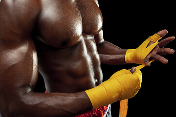 Image showing Afro American boxer is wrapping hands with bandage