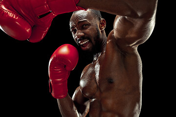 Image showing Hand of boxer over black background. Strength, attack and motion concept