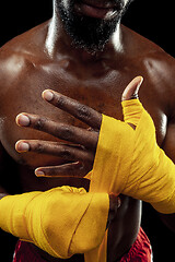 Image showing Afro American boxer is wrapping hands with bandage