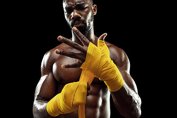 Image showing Afro American boxer is wrapping hands with bandage