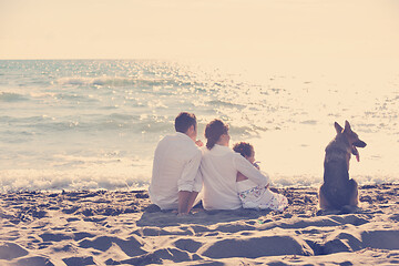 Image showing happy family playing with dog on beach