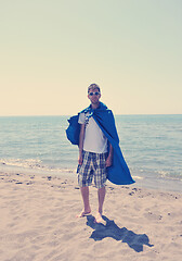 Image showing funny superhero standing on beach