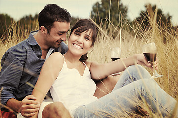 Image showing happy couple enjoying countryside picnic in long grass