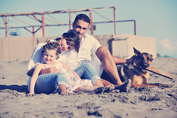 Image showing happy family playing with dog on beach