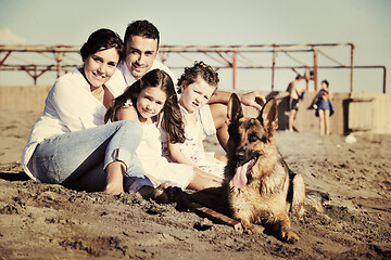 Image showing happy family playing with dog on beach