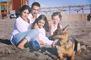 Image showing happy family playing with dog on beach