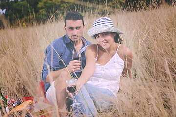 Image showing happy couple enjoying countryside picnic in long grass