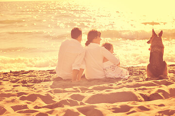 Image showing happy family playing with dog on beach