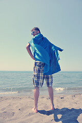 Image showing funny superhero standing on beach