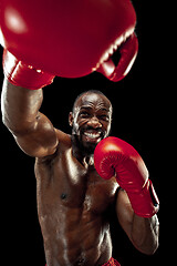 Image showing Hand of boxer over black background. Strength, attack and motion concept