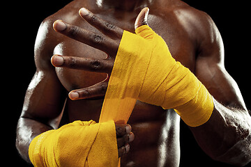 Image showing Afro American boxer is wrapping hands with bandage