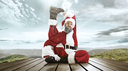 Image showing Santa Claus with traditional red white costume in front of white snow winter landscape panorama