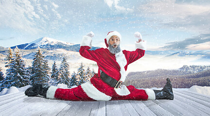 Image showing Santa Claus with traditional red white costume in front of white snow winter landscape panorama