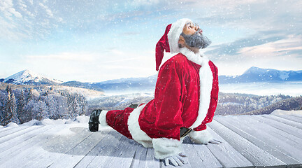 Image showing Santa Claus with traditional red white costume in front of white snow winter landscape panorama