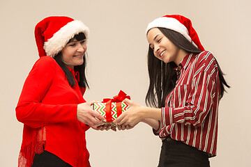 Image showing Happy family in Christmas sweater posing on a red background in the studio.