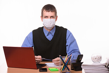 Image showing Portrait of a male office worker in a protective medical mask at the workplace