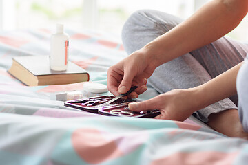 Image showing Female hand takes a nail file from a cosmetic set