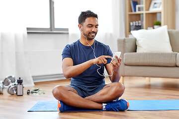 Image showing indian man with smartphone on exercise mat at home