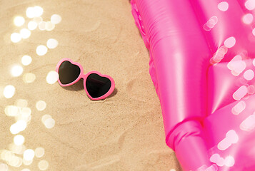 Image showing sunglasses and pink swimming mattress on beach