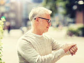 Image showing senior man checking time on his wristwatch