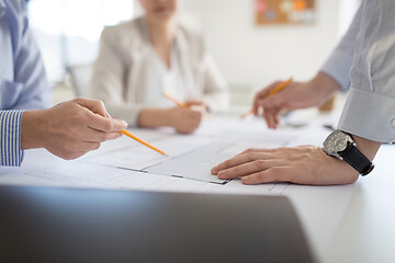 Image showing close up of architects with blueprint at office