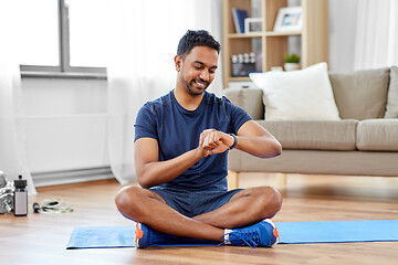 Image showing smiling indian man with fitness tracker at home