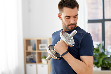 Image showing man exercising with dumbbell at home