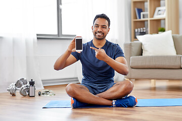 Image showing indian man with smartphone on exercise mat at home