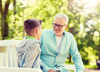 Image showing grandfather and grandson talking at summer park