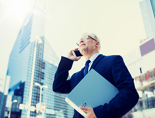 Image showing senior businessman calling on smartphone in city